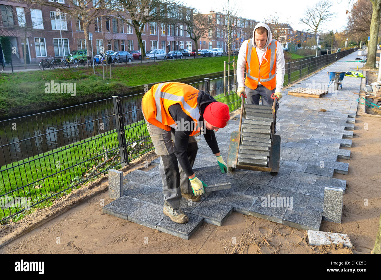 Paviours bei der Arbeit in der Straße in der Stadt Stockfoto