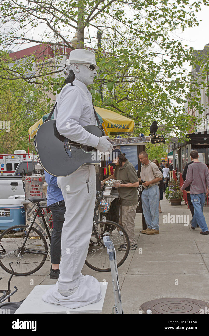 Asheville, North Carolina, USA - 26. April 2013: "Mann In weiß" eine lebende Statue darstellt und spielt Gitarre Tipps auf der Straße Stockfoto