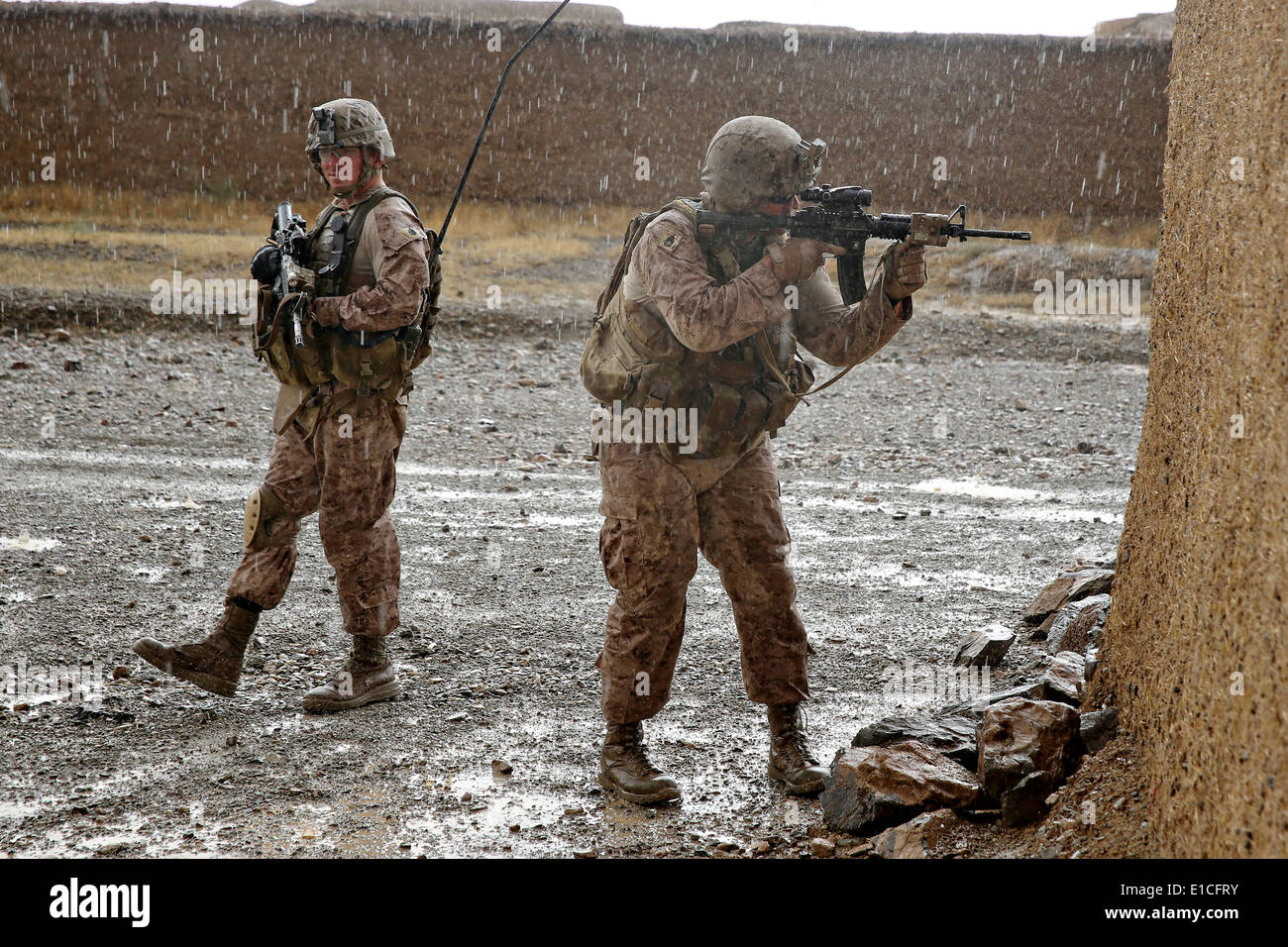 US-Marines mit dem 1. Bataillon, 7. Marineregiment patrouillieren während einer Mission zur Niederschlagung von Aufständen in einem Regen Sturm 16. Mai 2014 in Larr Dorf, Provinz Helmand, Afghanistan. Stockfoto