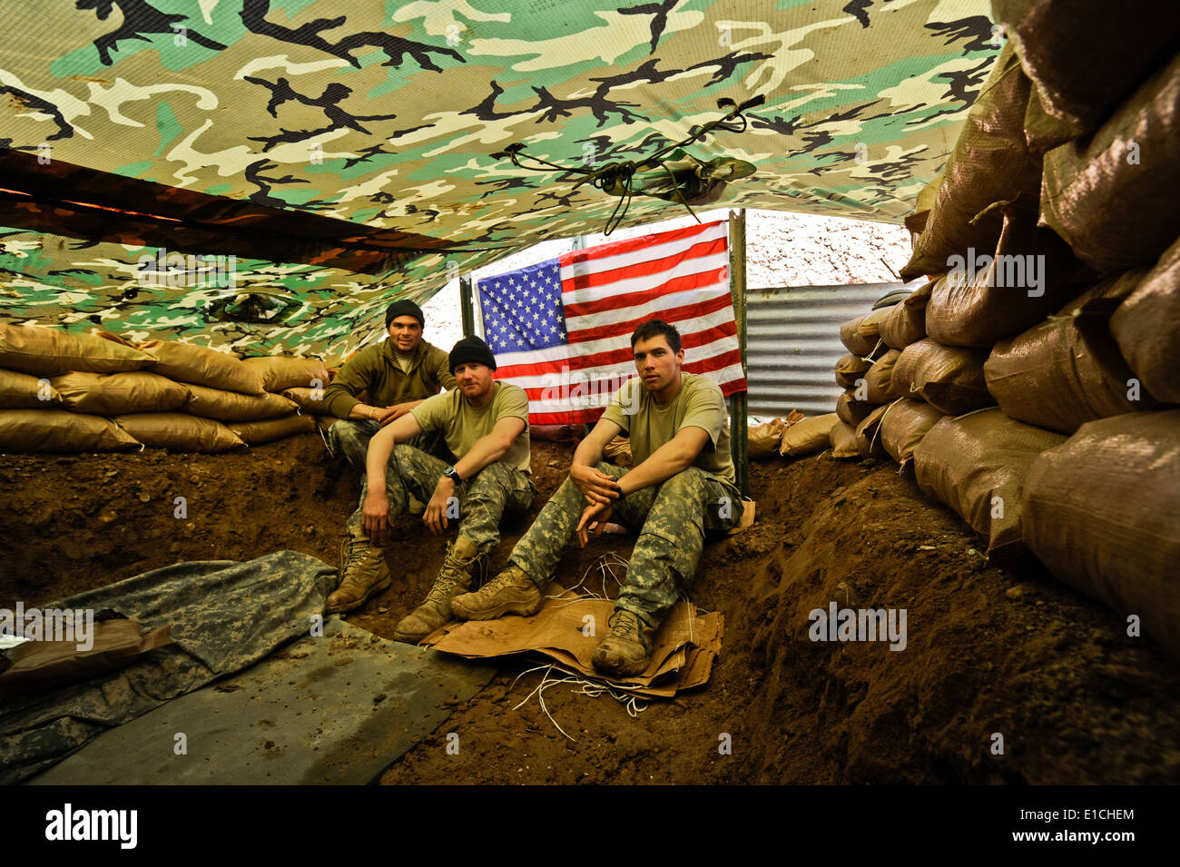 Von links sitzen US Army Spc. Charles Henderson, Pfc. Collen Wells und Spc. Marshall Hodge in einer improvisierten Unterschlupf decorat Stockfoto