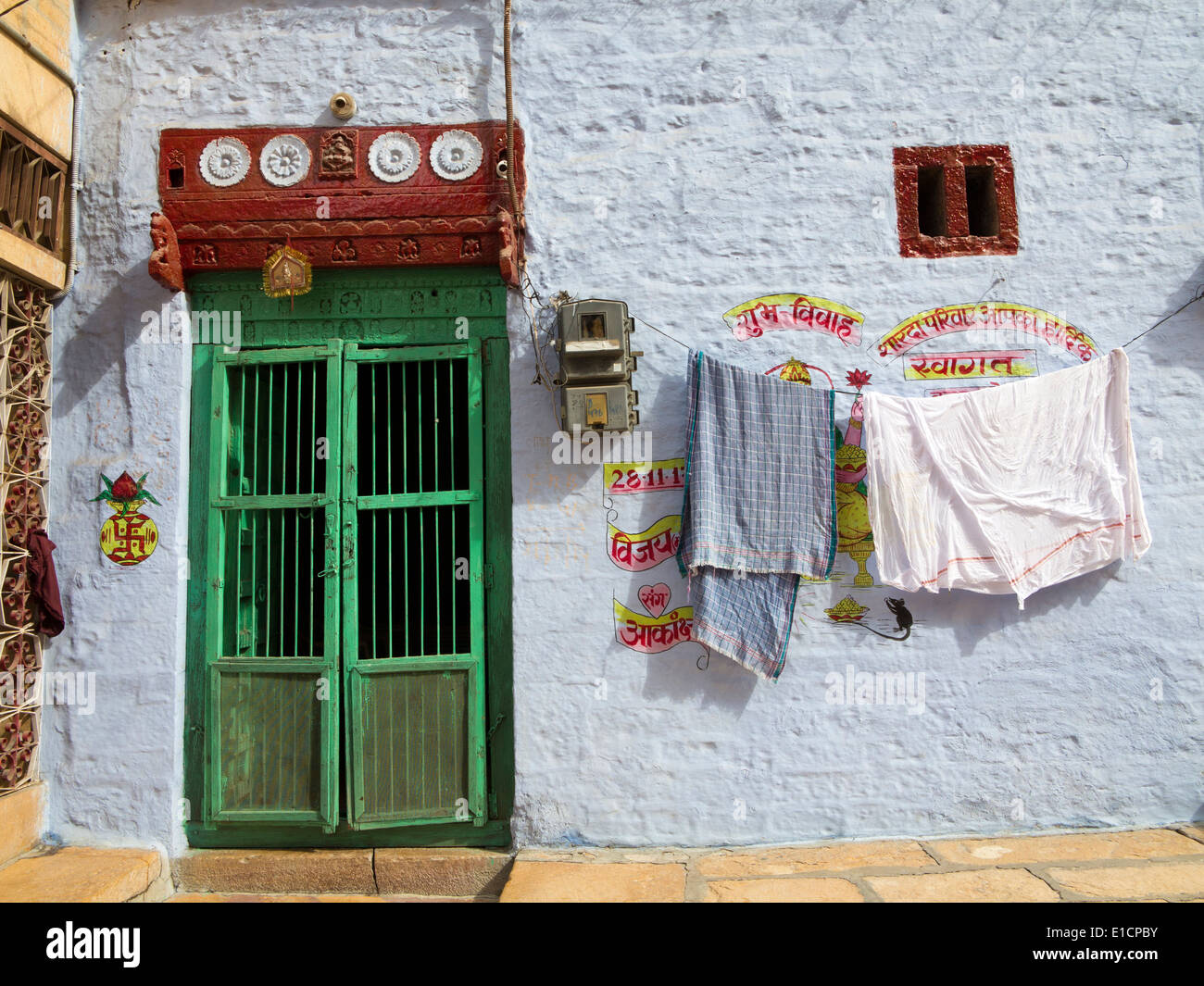 Indien, Rajasthan, Jaisalmer, waschen, Trocknen auf Linie außerhalb, blau gemaltes Haus mit grünen Tür Stockfoto