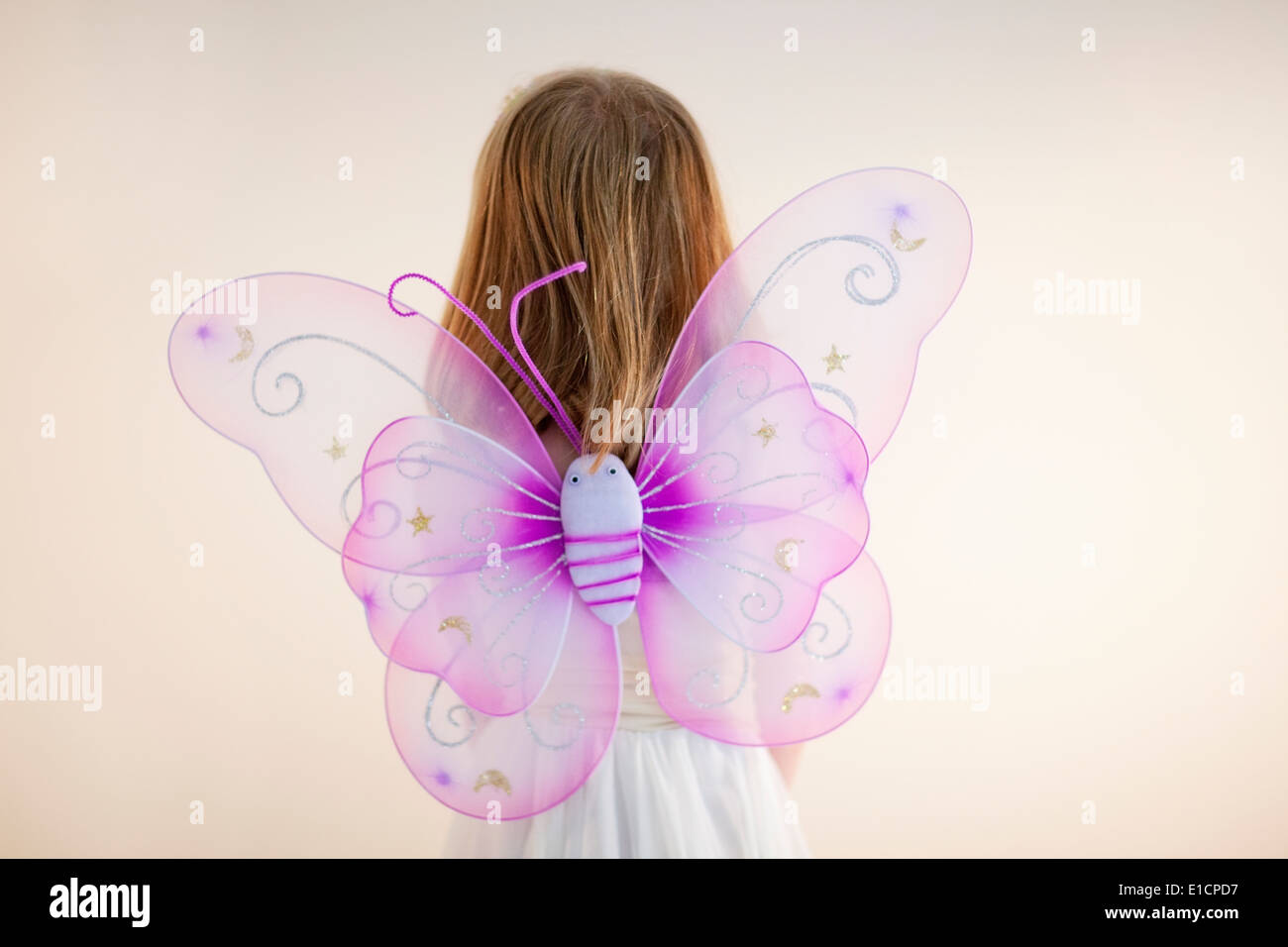 Ein junges Mädchen mit rosa Schmetterling Feenflügel Stockfoto