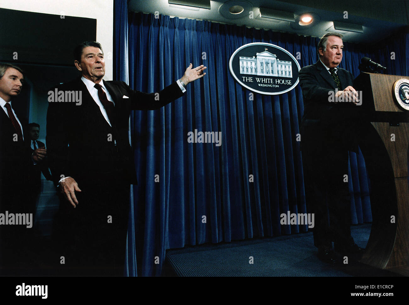Ronald Reagan. Präsident Reagan deutete zum Attorney General Ed Meese bei einem White House Press Briefing auf Iran-Contra. Die Stockfoto