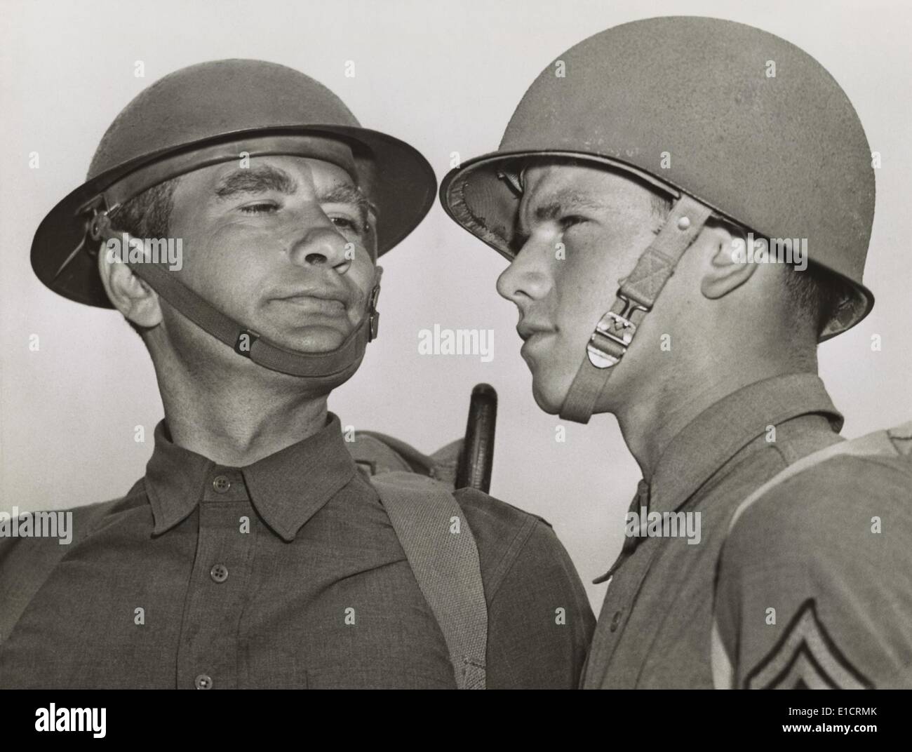 Soldaten in den alten und neuen Armee-Helme in Fort Benning, Georgia, 25. April 1941. Die 2. Weltkrieg neuartige Tests hat eine Stockfoto