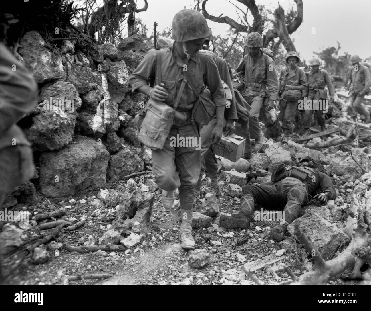 US-Marines durchlaufen ein kleines Dorf, wo die japanische Soldaten tot legen. Okinawa, April 1945. Dem 2. Weltkrieg. (BSLOC 2013 13 84) Stockfoto
