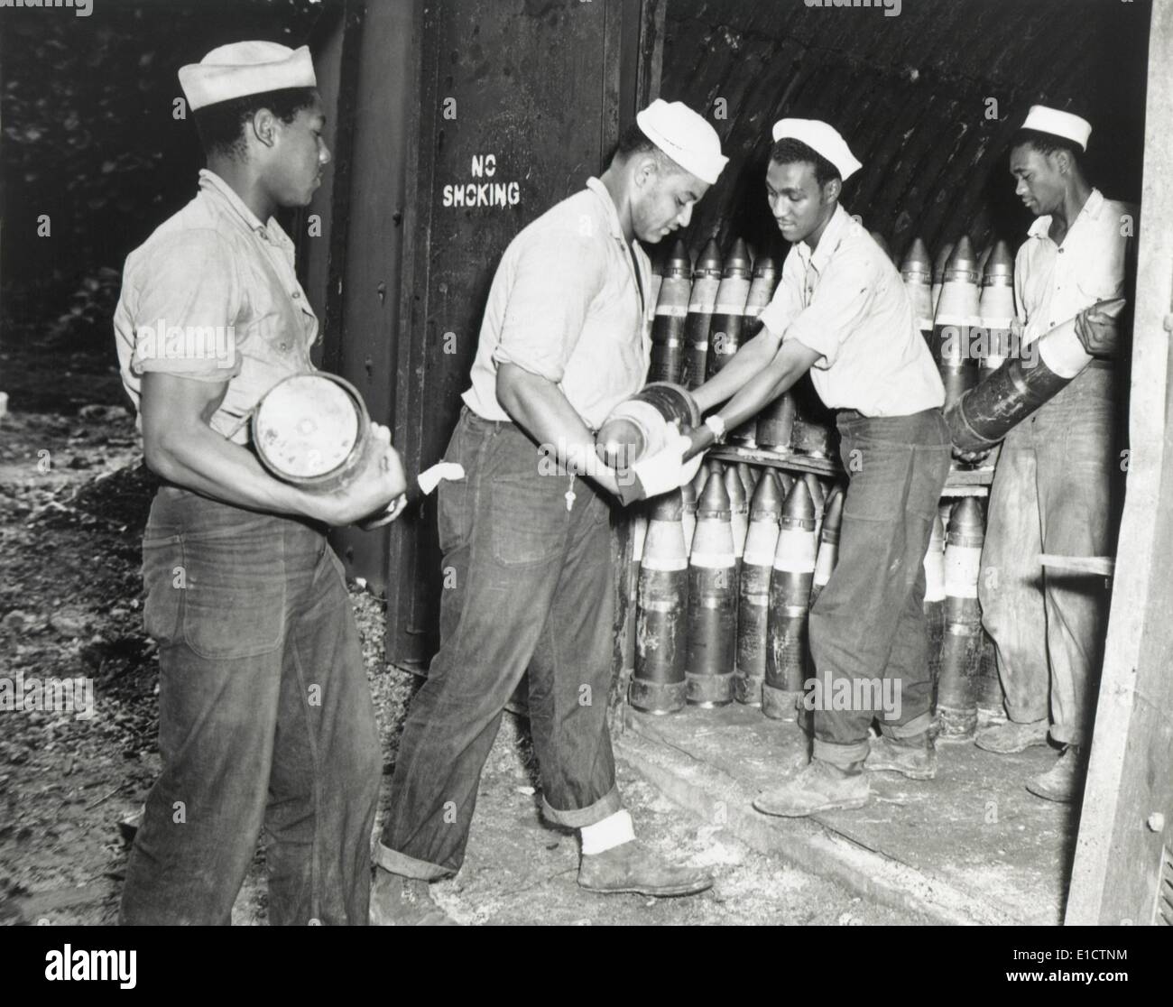 African American Munition Handler in der US-Navy im 2. Weltkrieg. Sie passieren Schalen für 6-Zoll-Geschütze in Zeitschriften an der Stockfoto