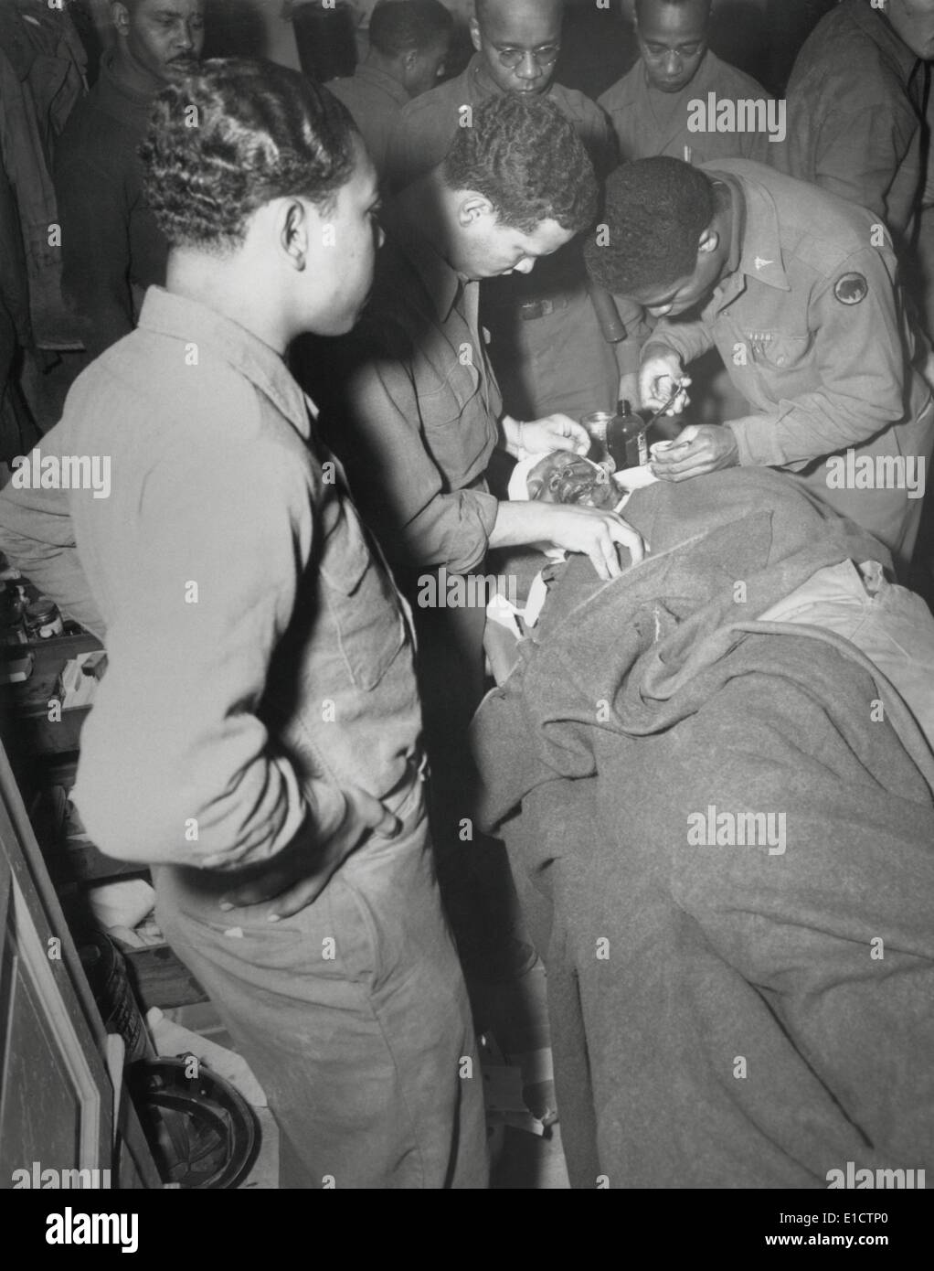 African American Army Chirurg Stiche Gesicht und Schulter Wunden die Pietrasanta und Umgebung, Italien. 10. Februar 1945. Capt Ezekia Stockfoto