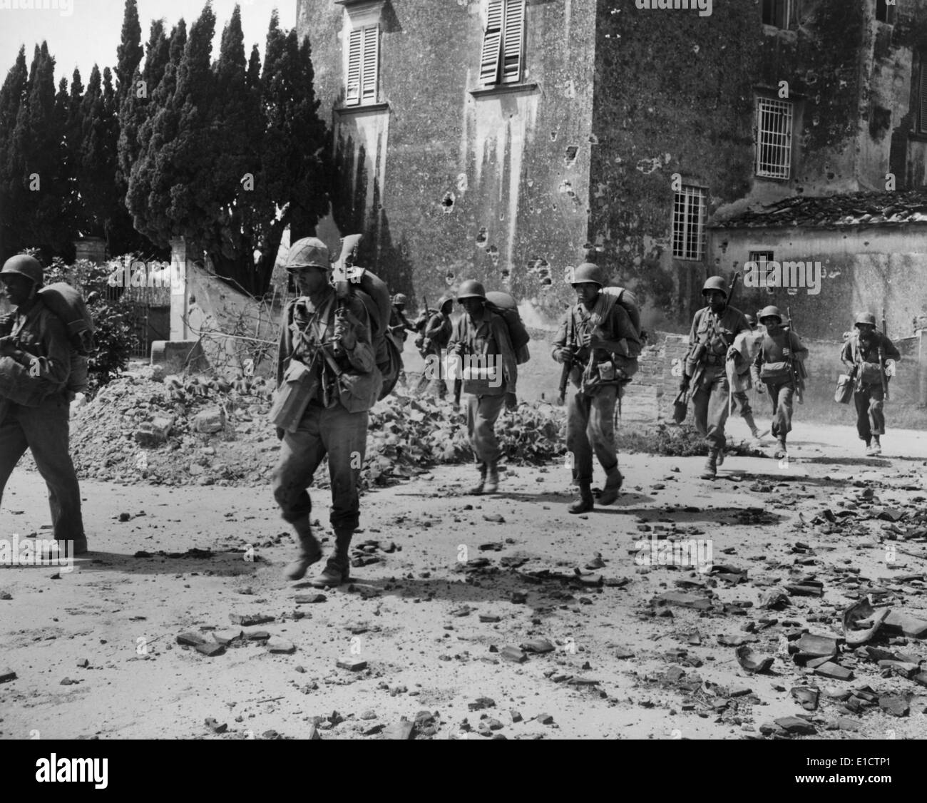 African American kämpfenden Soldaten auf Patrouille in der Nähe von zerbombten Gebäude irgendwo in Europa im Jahr 1944. Im Frühjahr 1944, die USA Stockfoto