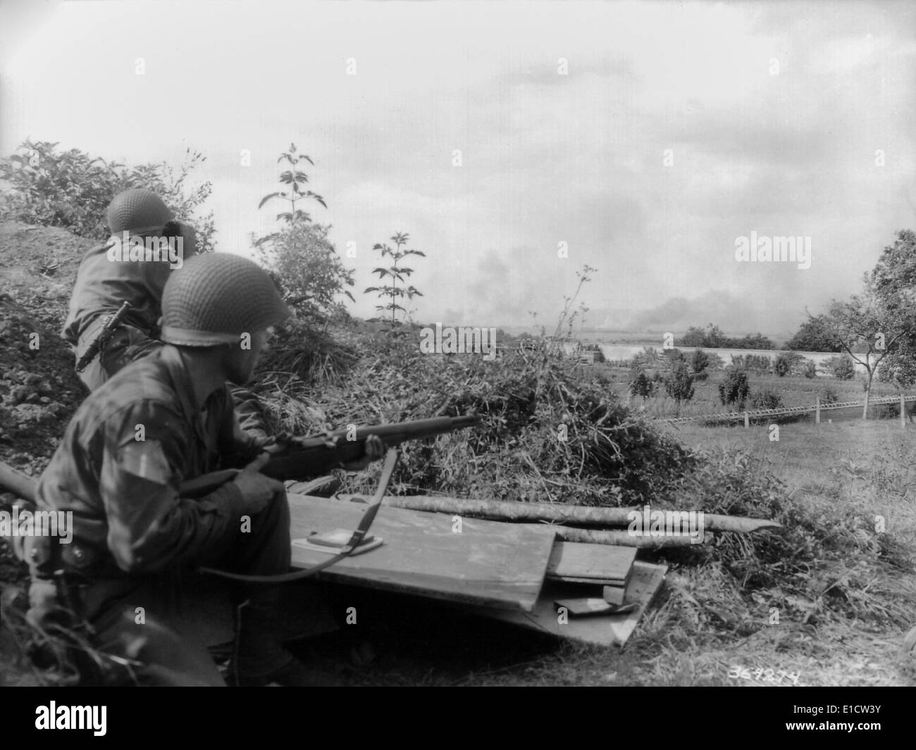 Zwei US-Soldaten beobachten Sie Rauch aus der Schlacht von Falaise Tasche. Sie waren auf einer Aufklärungs-Patrouille, hinter der Burg Stockfoto