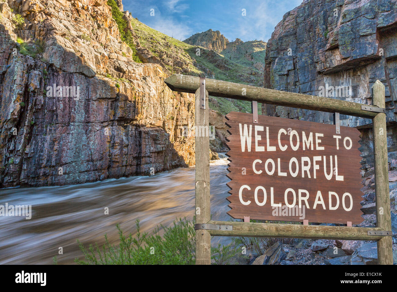 Willkommen im bunten Colorado am Straßenrand Holzschild mit einem Canyon und Whitewater Fluss im Hintergrund Stockfoto