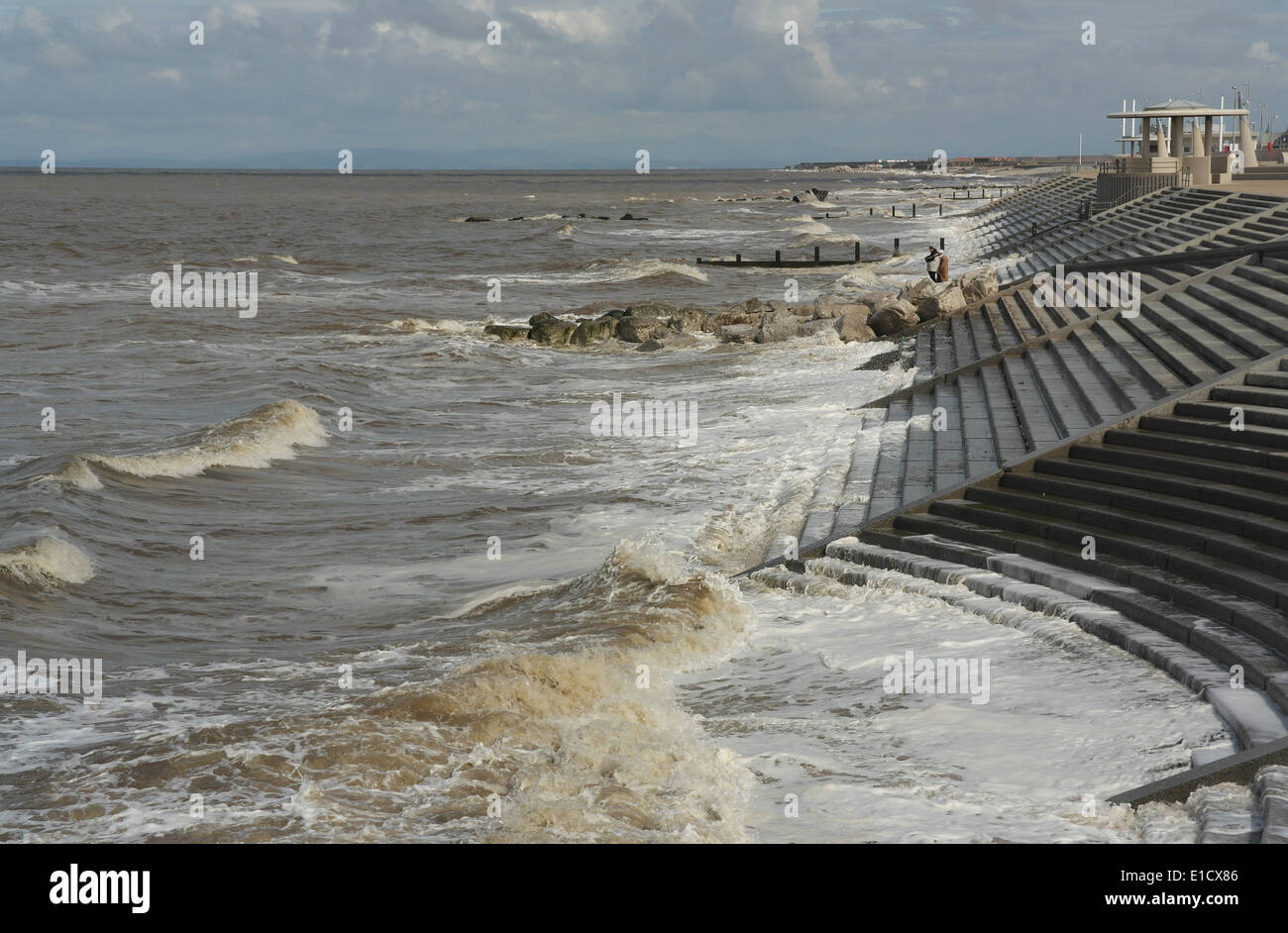 Sonnige graue Wolken anzeigen, Norden zu Rossall, Flut Meereswellen brechen, Buhnen und Schritte Cleveleys Promenade, Fylde Küste, UK Stockfoto