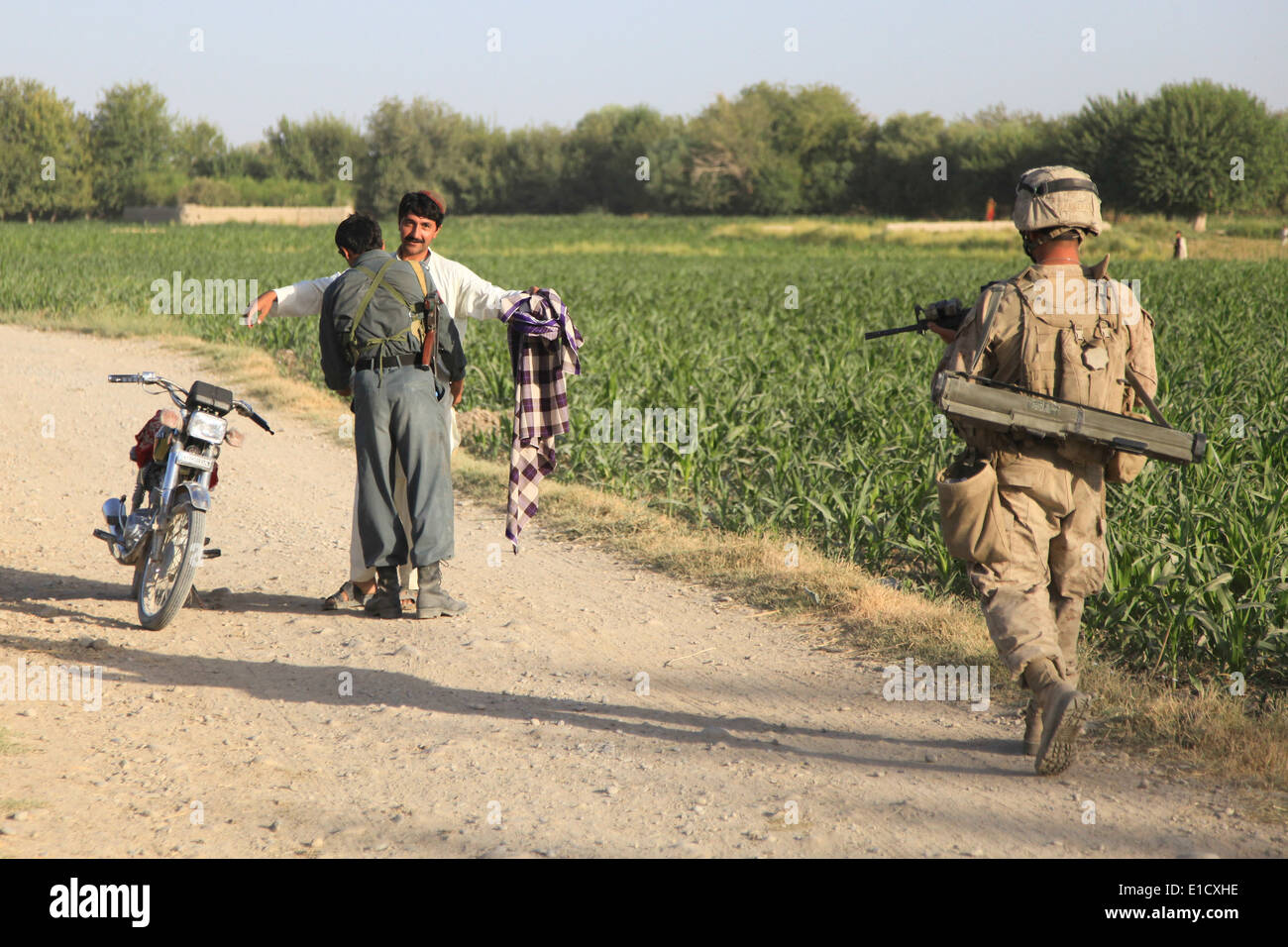 Ein Afghan National Police Officer sucht einen Mann als US-Marines mit 1. Bataillon, 5. Marineregiment bieten Sicherheit durin Stockfoto