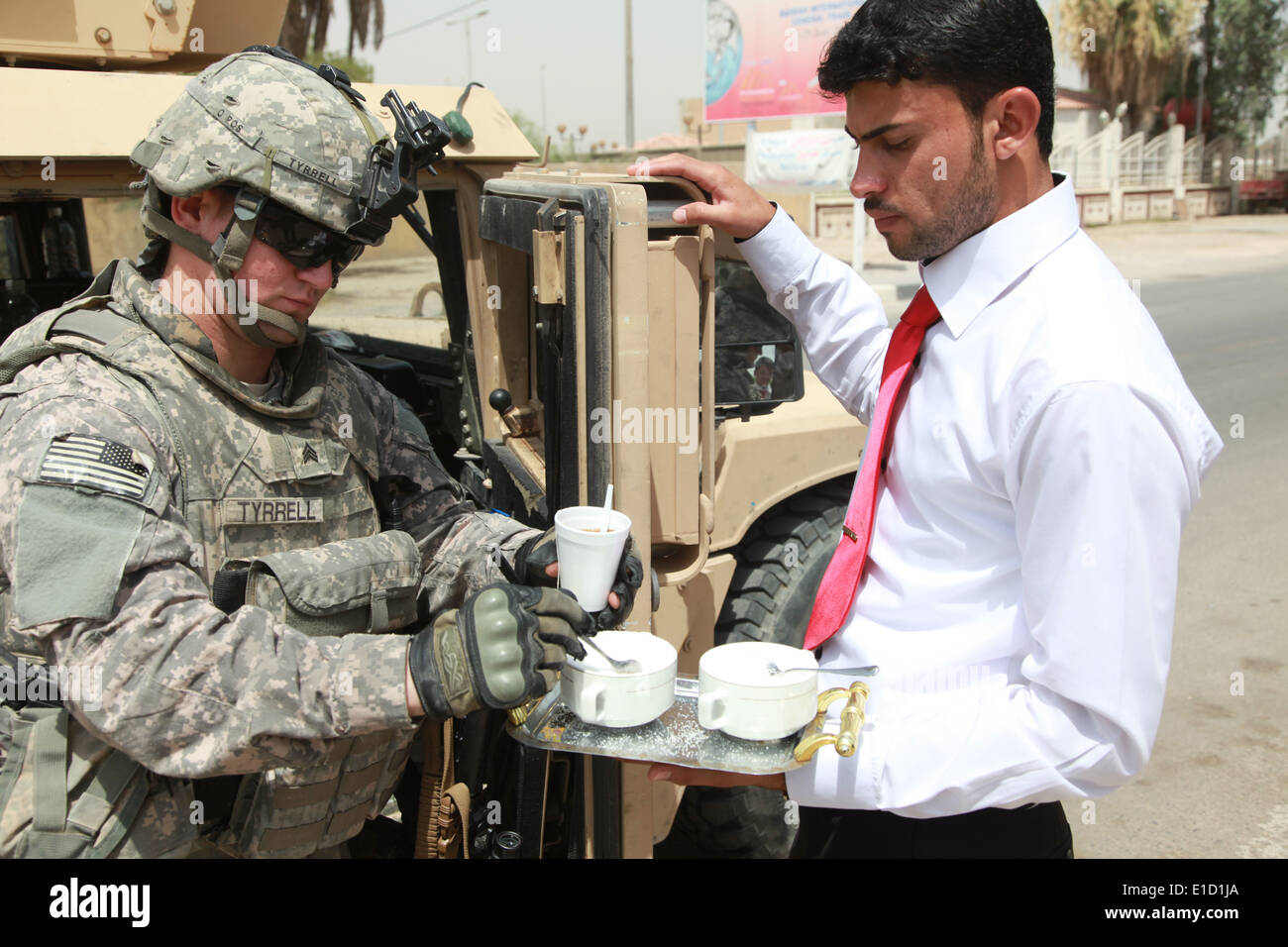 US Armee Sgt. William Tyrrell akzeptiert eine Tasse Tee per Sheik Saydi Ali al-Interesse Personal während der Gewährleistung der Sicherheit während Stockfoto