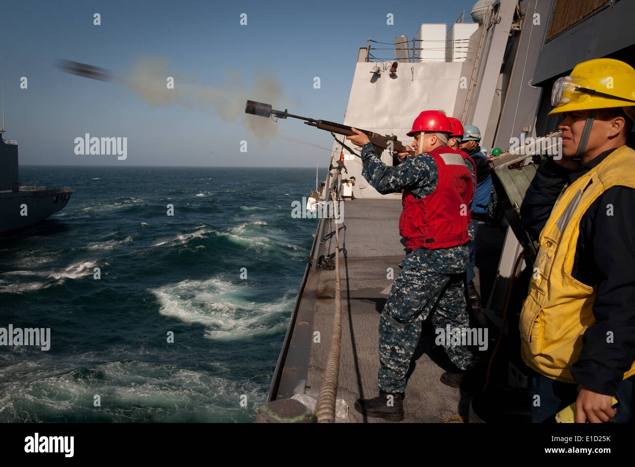 US Marine Gunner Mate 2. Klasse Steven Moore, stationiert an Bord der USS New Orleans (LPD-18), feuert eine Schuss Linie über in die USA Stockfoto