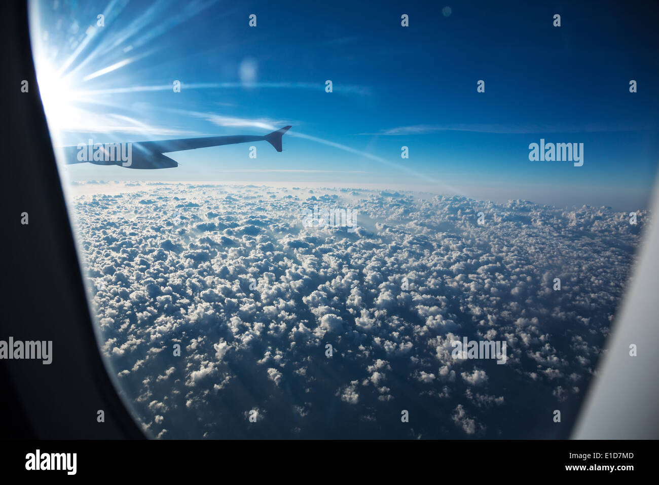 Wolken und Himmel gesehen durch Fenster eines Flugzeugs Stockfoto