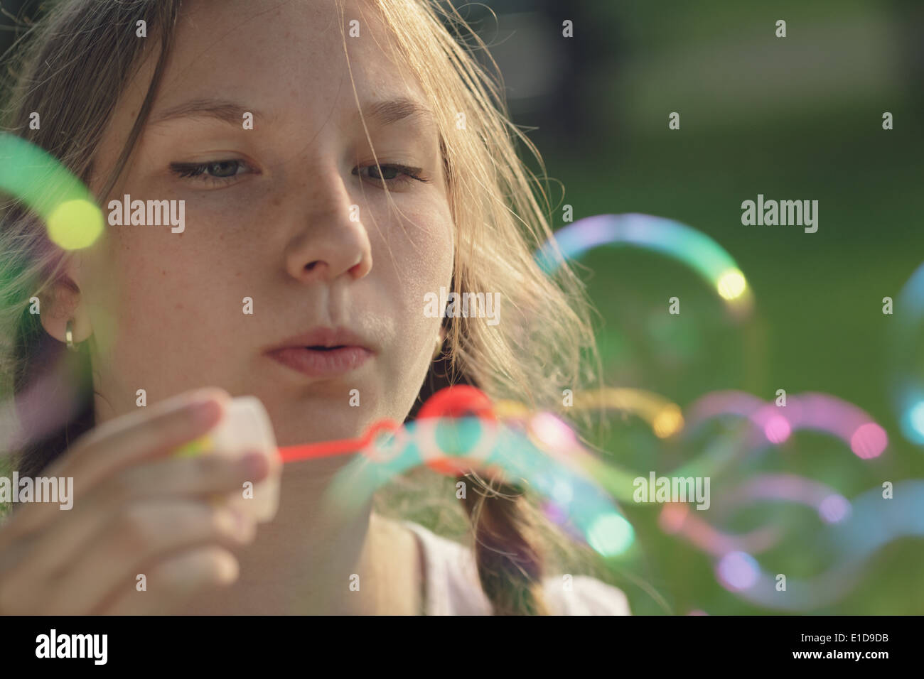 junges Mädchen bläst Seifenblasen im Park, im Sommer Stockfoto