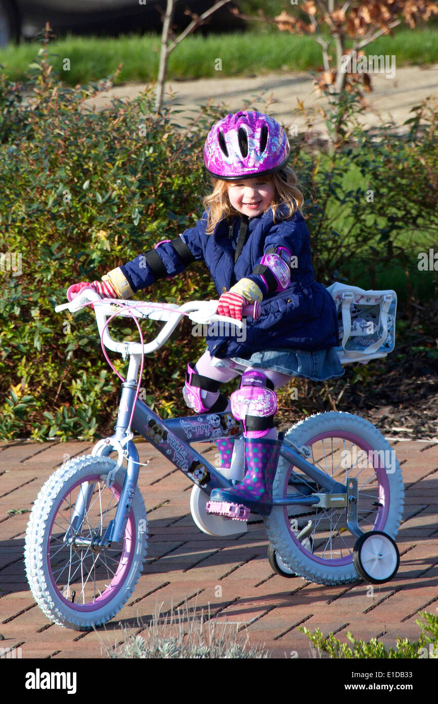 Vier 4 Jahre altes Mädchen mit ihrem Fahrrad Stockfoto