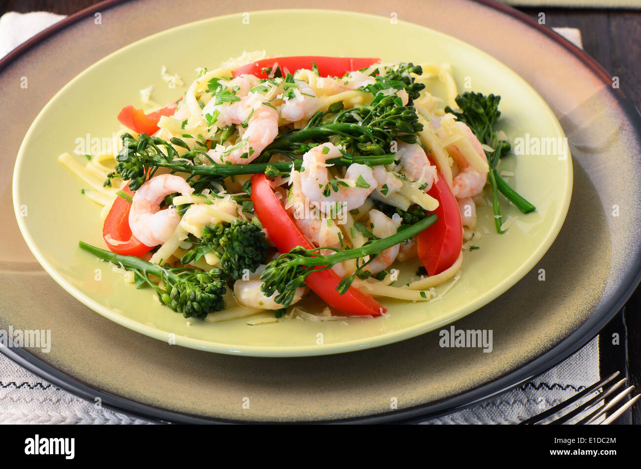 Linguine mit Garnelen, Broccolini und Paprika auf eine Holzoberfläche Stockfoto
