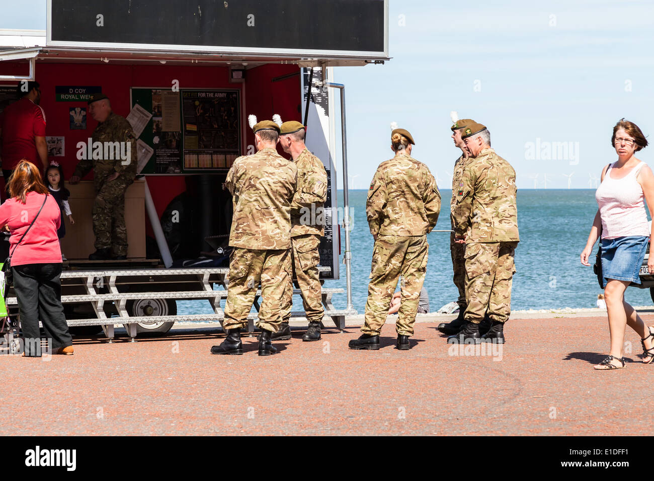 Llandudno, Wales, UK. 17. Mai 2014. Mann mit Mädchen im Chat zu einem Soldaten im mobile Recruiting Armee-Einheit auf Promenade. Stockfoto