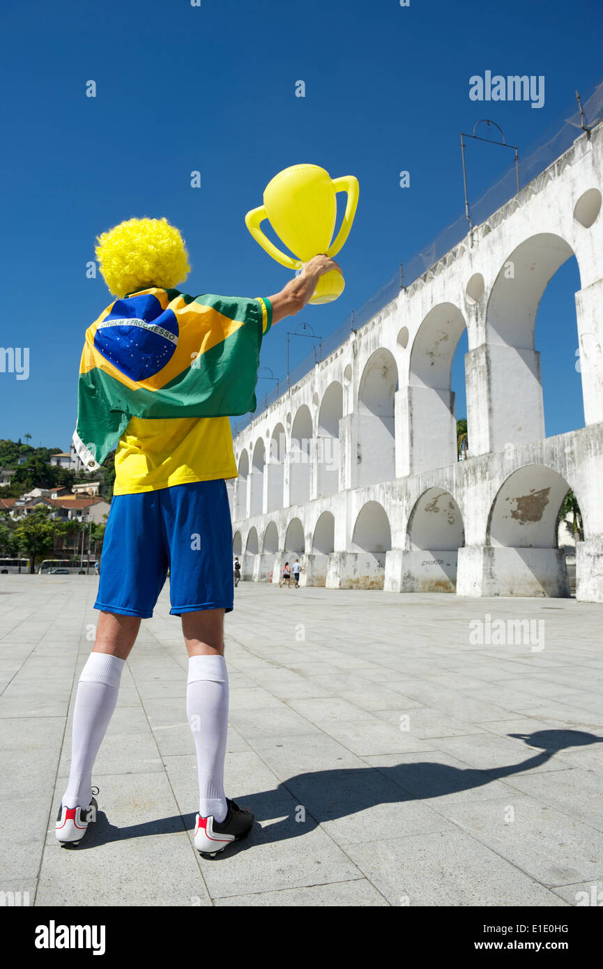 Mann in Brasilien Flagge feiern hält Trophäe über Arcos da Lapa Bögen Rio De Janeiro Brasilien Stockfoto