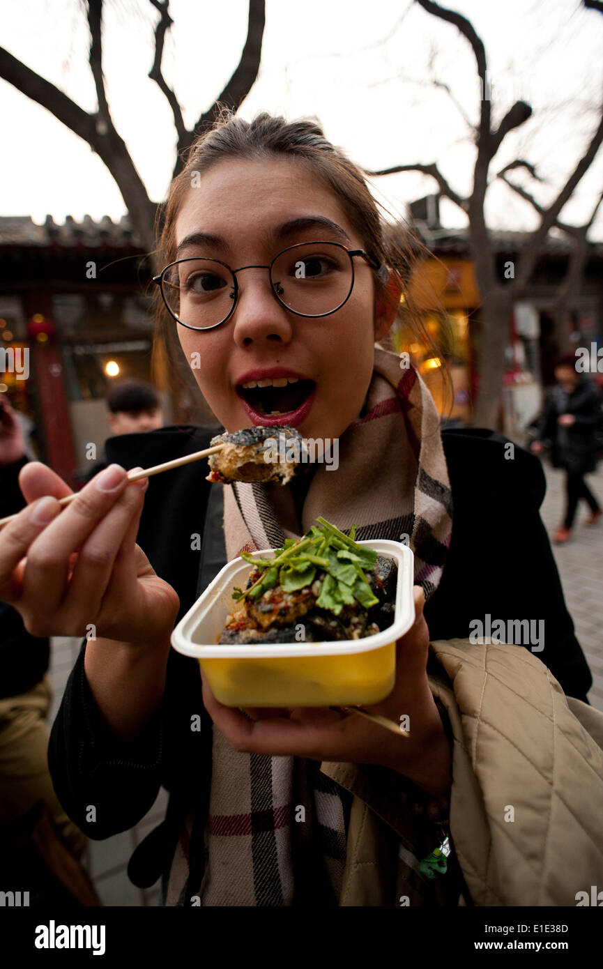 Mädchen essen Chou Doufu (buchstäblich "stinky Tofu), ein typisches street Food Sie in Peking finden Stockfoto