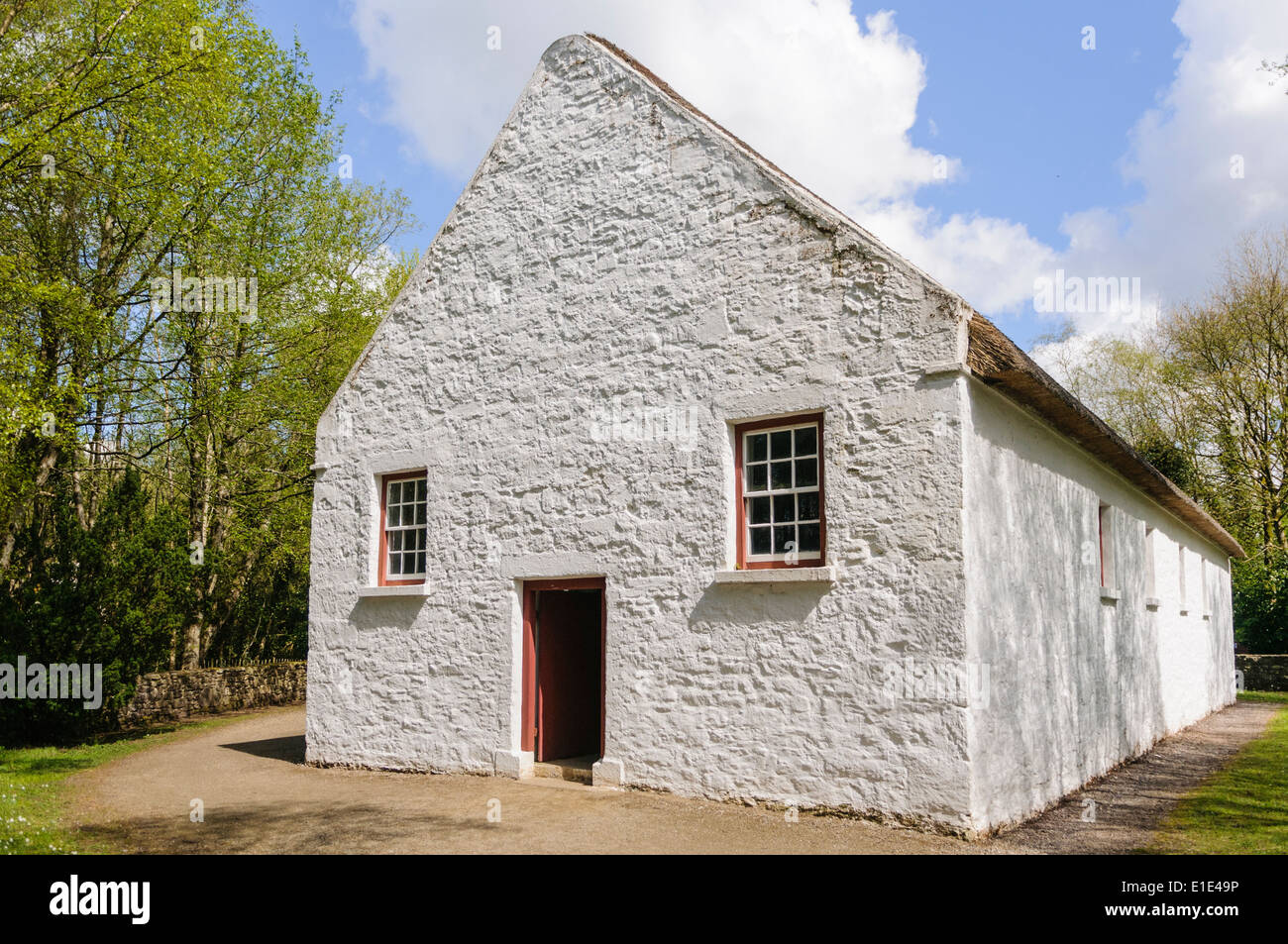 Eine irische Landkirche mit weiß getünchten Wänden und Strohdach in Ulster American Folk Park, Nordirland Stockfoto