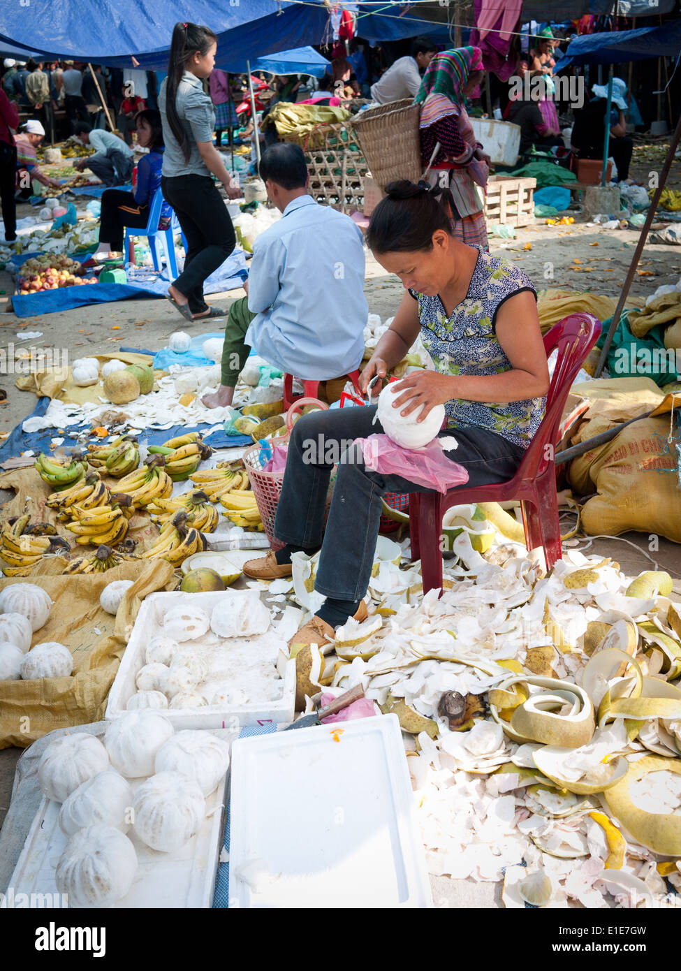 Ein Markt-Verkäufer schält Pampelmusen am Bac Ha Markt in Bac Ha, Provinz Lao Cai, Vietnam. Stockfoto