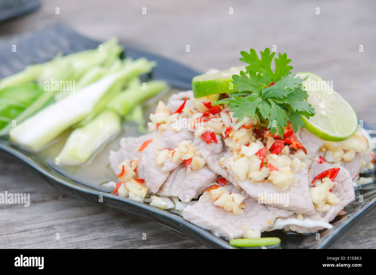 Großaufnahme würziges Schweinefleisch mit Chili-Sauce, frische Limette auf Top und frischen Grünkohl Stockfoto