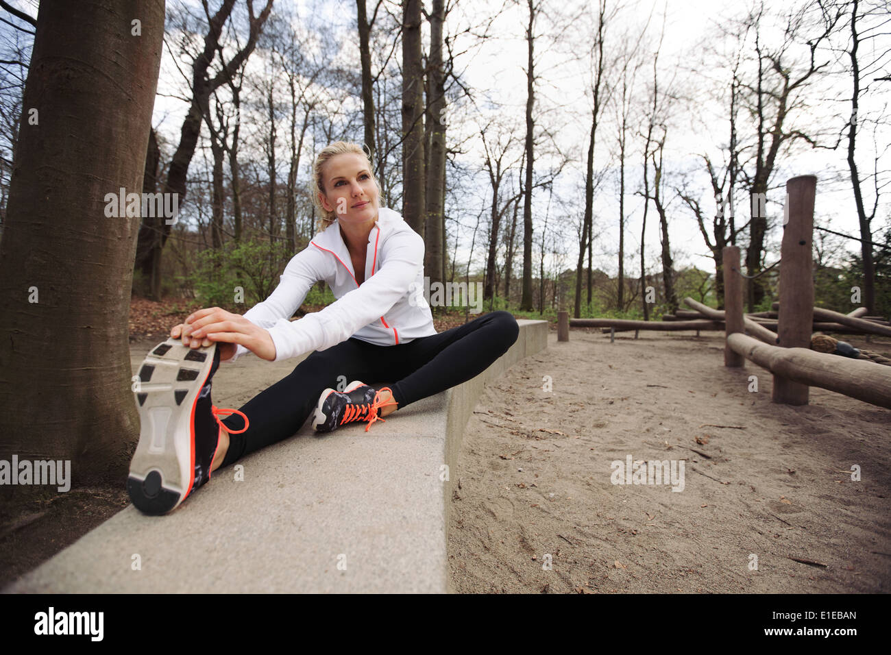 Frau, die stretching-Übung im Park zu tun. Kaukasische weibliches Modell in der Natur ausüben. Stockfoto