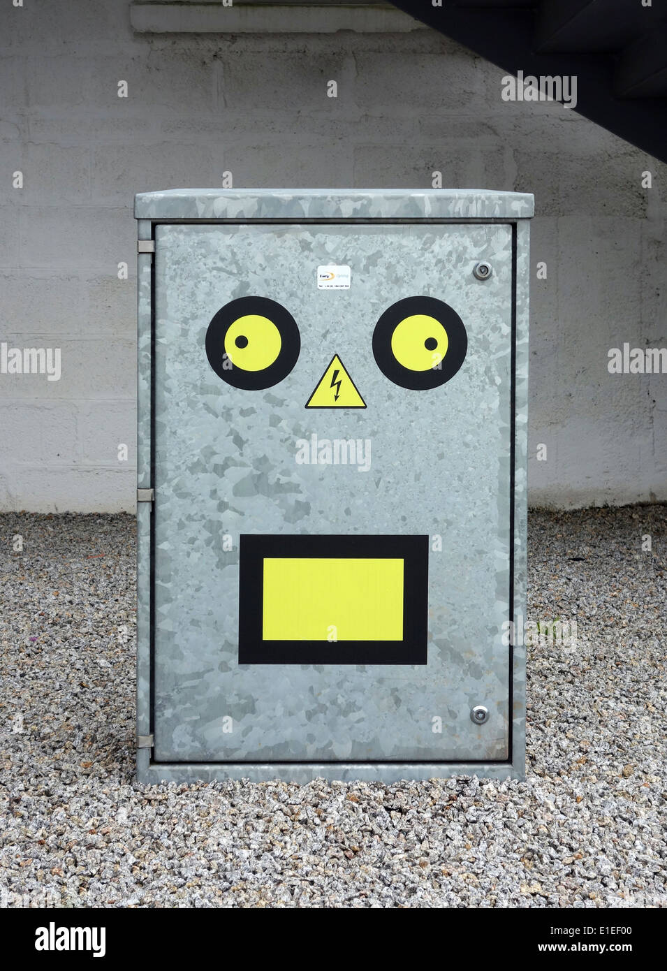 Sicherheitsetiketten gemacht in ein lustiges Gesicht auf eine Strom-Verteilerkasten Stockfoto