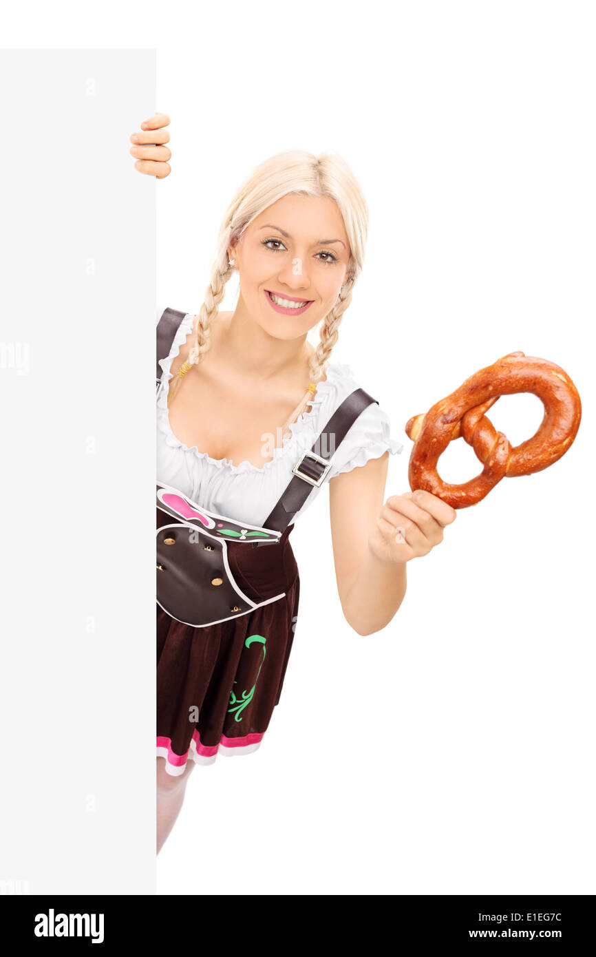 Bayerische Mädchen hält eine Brezel hinter Blindplatte Stockfoto