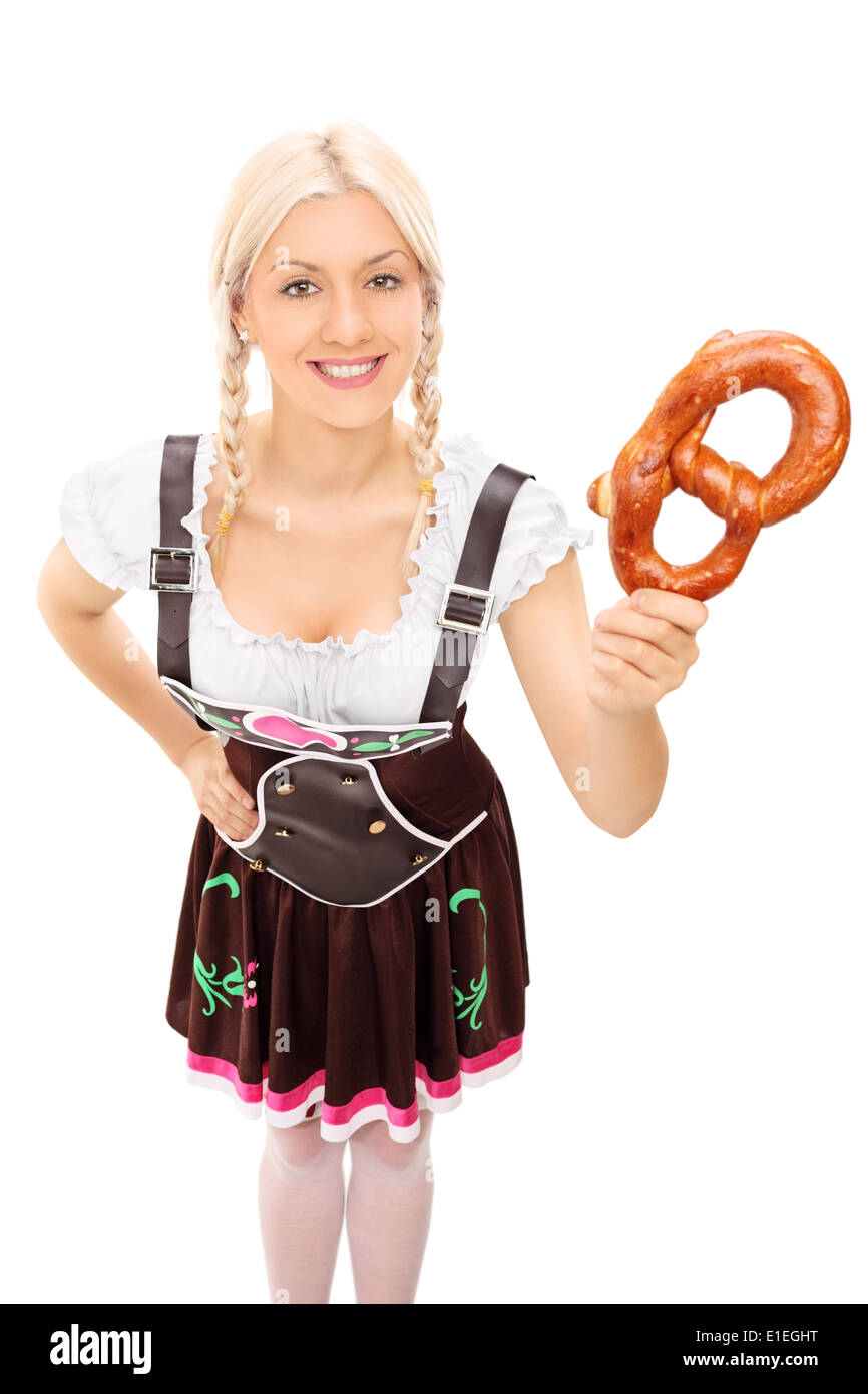 Frau in bayrischer Tracht hält eine Brezel Stockfoto