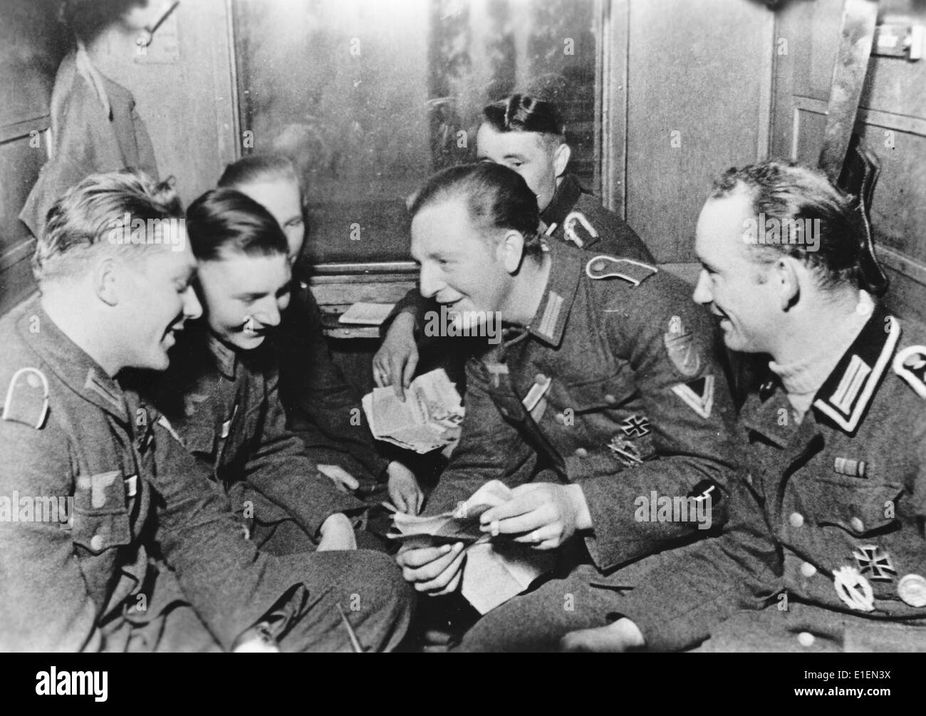 Soldaten der deutschen Wehrmacht auf dem Heimweg auf verlassen von der Ostfront. Ort unbekannt. Propaganda-Text! aus Nazi-Nachrichten Berichterstattung auf der Rückseite des Bildes vom 19. Mai 1944: "eine Gruppe von Stoßtruppen der Ostfront besucht die Heimat. Gauleiter (Abteilungsleiter ein Verwaltungsbezirk während der NS-Zeit) der Gau Weser-Ems forderte ein Offizier und 13 Unteroffiziere aus eine Nord-deutsche Infanterie-Division östlich von Polozk nach Oldenburg bereitgestellt. Die Infanterie-Division hat diese erfahrene Männer direkt aus Gräben, Bunkern und kämpfende Positionen des Mai abgeholt. Stockfoto