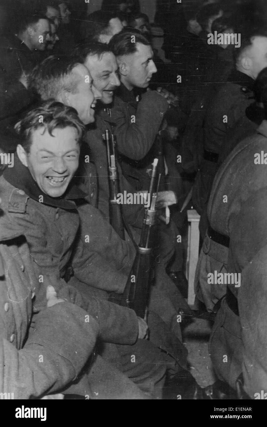 Deutsche Soldaten nehmen im Februar 1942 an einem Soldaten-Kabarett an der Ostfront Teil. Der ursprüngliche Text der Nazi-Propaganda auf der Rückseite des Bildes lautet: "Ein Blick in den Zuschauerbereich während einer Darbietung eines Soldaten-Kabaretts an der Ostfront. Die Soldaten amüsieren sich schwul, aber selbst hier im Theater geben sie ihre Gewehre nicht auf." Fotoarchiv für Zeitgeschichtee - KEIN KABELDIENST Stockfoto
