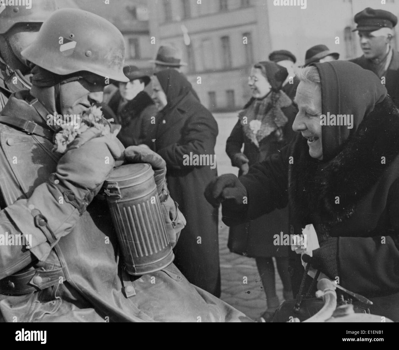 Nach der Übergabe des Memel Territory durch die litauische Regierung an das Dritte Reich in Klaipeda, Litauen, im März 1939 werden einzelne Soldaten feierlich von den Bewohnern begrüßt. Der Originaltext eines Nazi-Nachrichtenberichts auf der Rückseite lautet "Feiern für deutsche Truppen in befreitem Memel. Der Einmarsch deutscher Truppen wurde zu einer echten Triumphparade. Soldaten wurden von der überfreulichen Bevölkerung begrüßt und mit Blumen geschmückt. Vor Freude strahlt eine ältere Mutter einem Soldaten Blumen." Fotoarchiv für Zeitgeschichtee - KEIN KABELDIENST Stockfoto