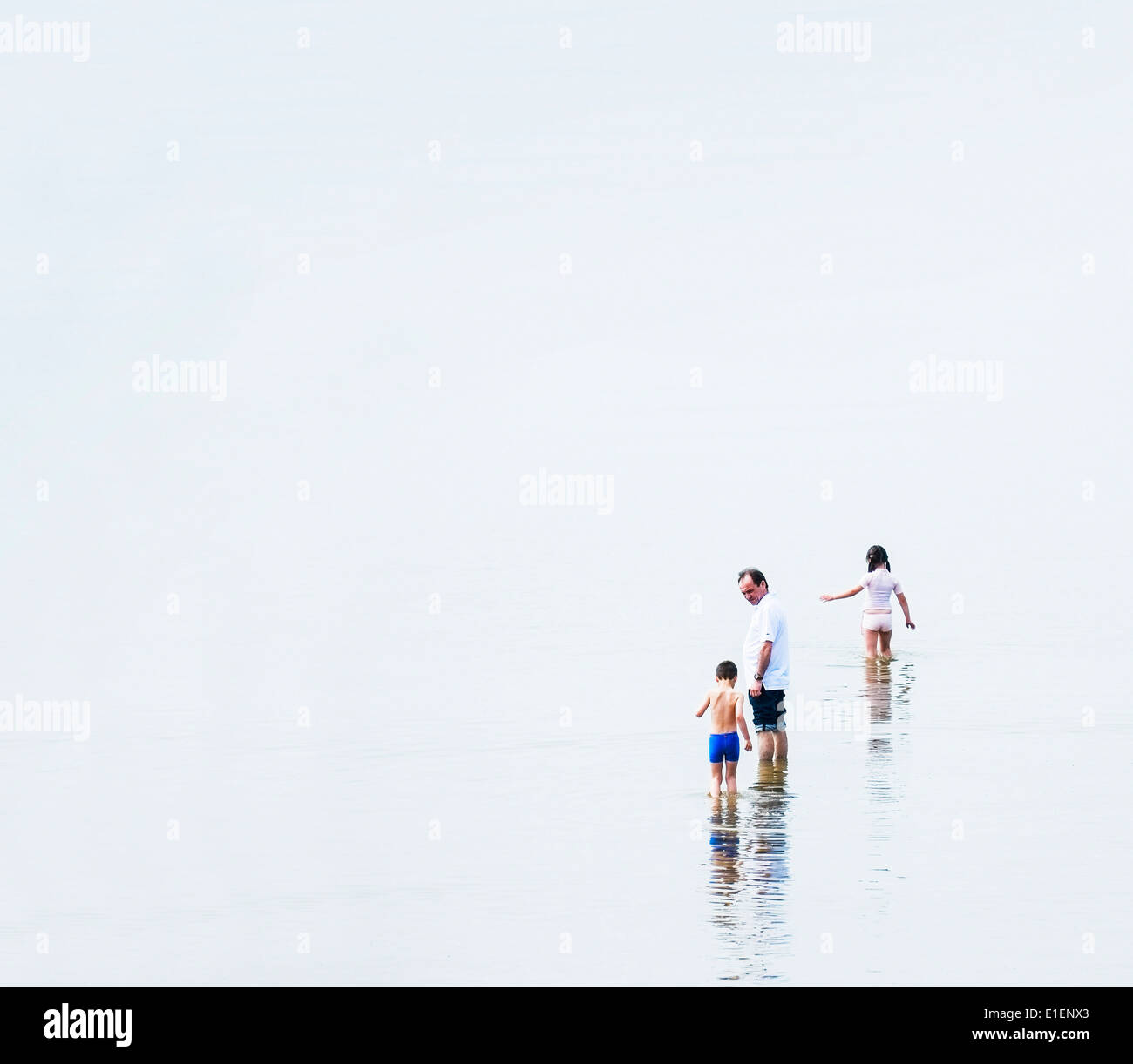 Ein Vater und seine Kinder Paddeln im Meer bei Southend. Stockfoto
