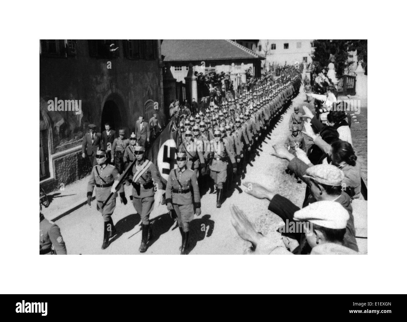 ANSCHLUSS AUSTRIA 12. Mär 1938 Hitler kündigt Anschluss-Annexion an Nazi-Wehrmachtseinheiten marschieren mit Hakenkreuzfahnen in die saluzende Menschenmenge ein Stockfoto