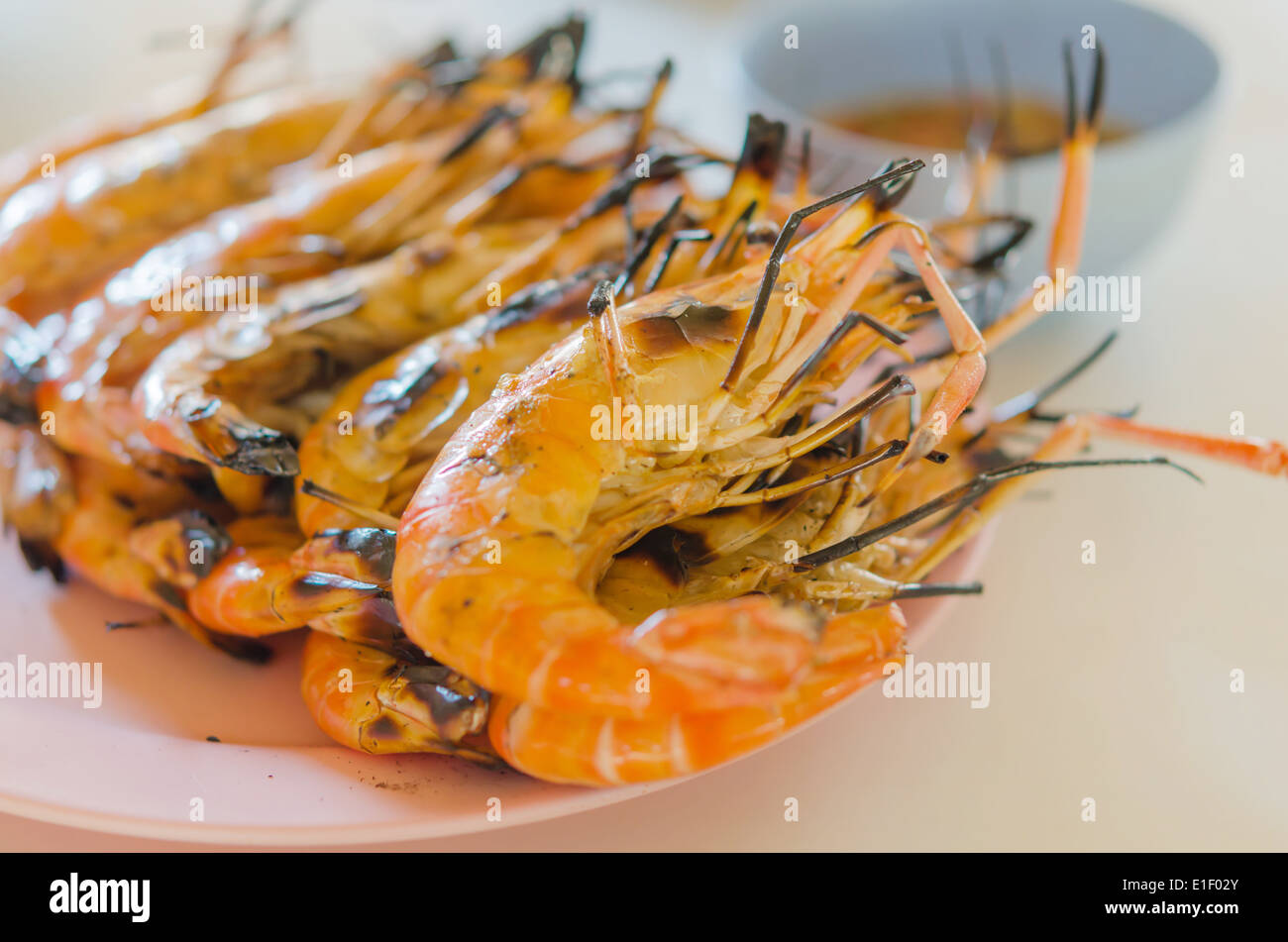 gegrillte Garnelen auf einem Teller am Tisch hautnah Stockfoto