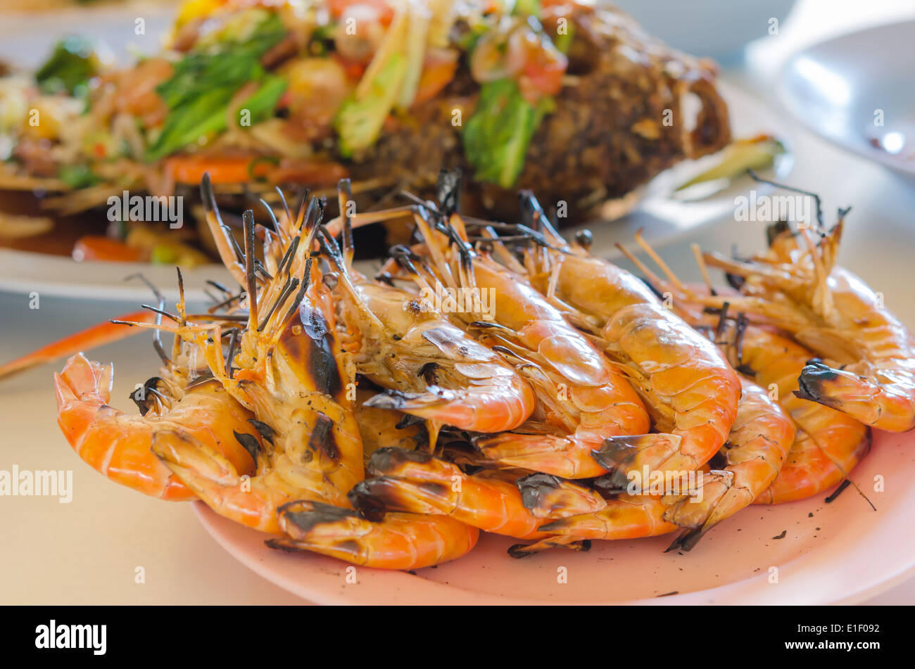 gegrillte Garnelen auf einem Teller am Tisch hautnah Stockfoto