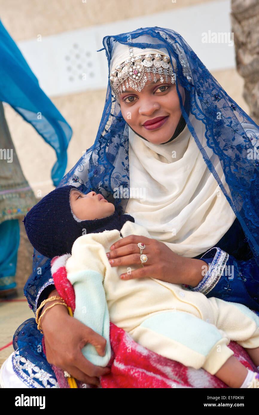 Eine omanische Mutter in traditioneller Tracht mit Baby in Muscat, in das Sultanat Oman. Stockfoto