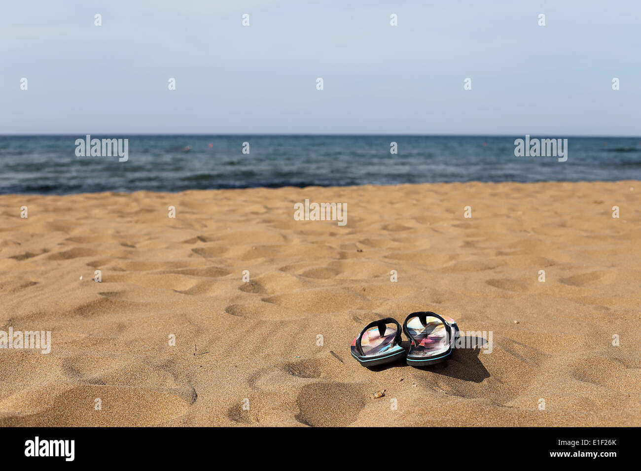 Flip Flops auf dem Strandsand Stockfoto