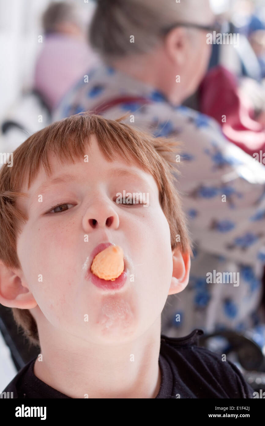 Ein kleiner Junge mit einer Eistüte ragte aus seinem Mund Stockfoto