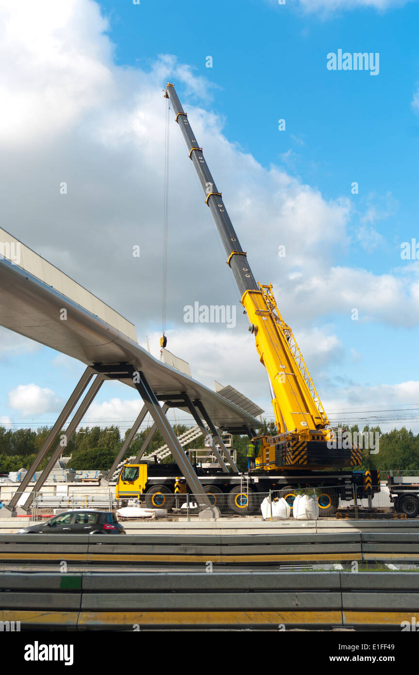 Bau eine Brücke über eine stark befahrene Straße mit einem großen Baukran Stockfoto