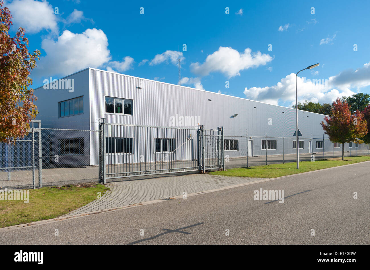 moderne Fassade eines Industriebaus, umgeben von einem Zaun mit Tor Stockfoto