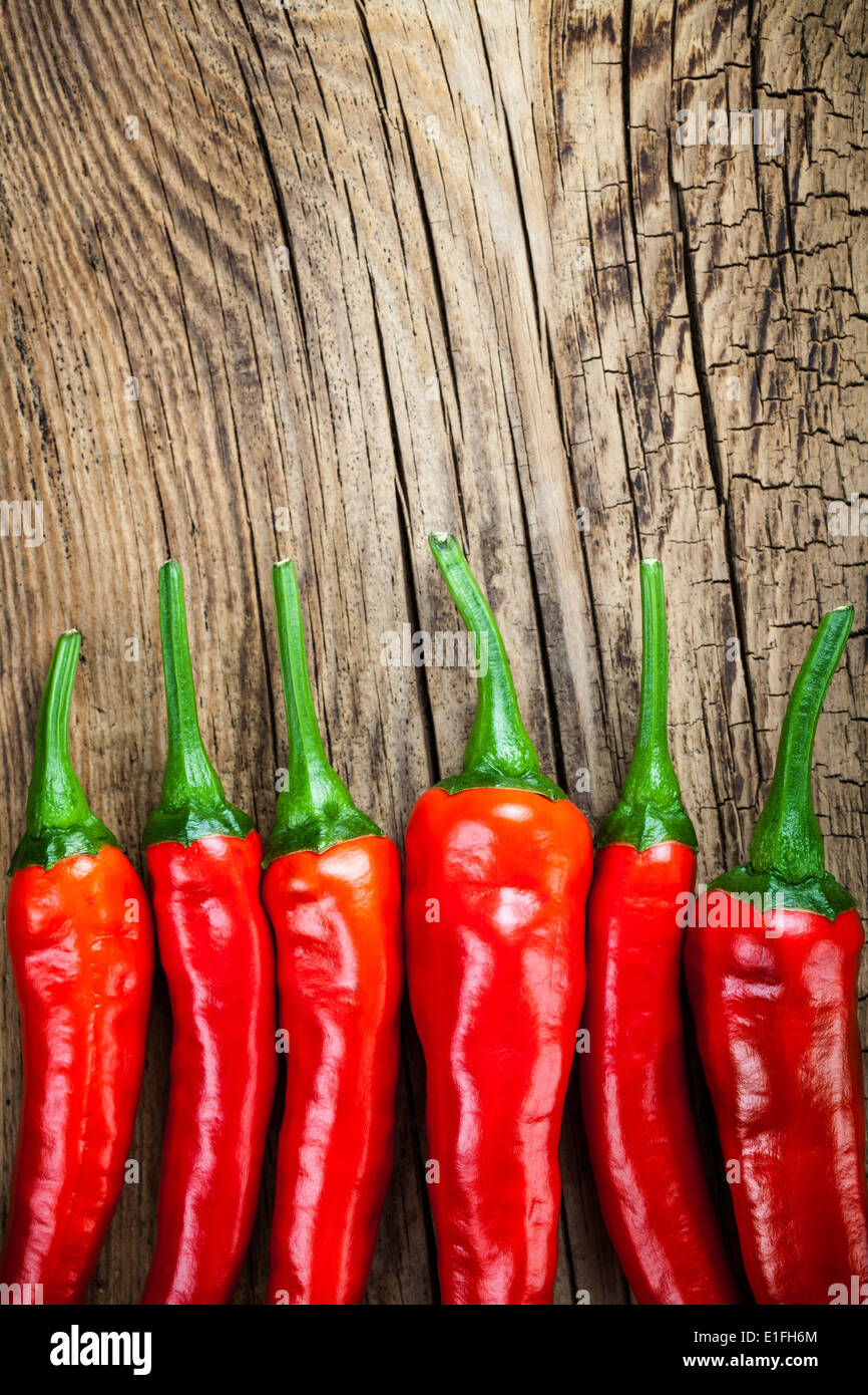 Rote Chilischote auf Holztisch Hintergrund. Kopieren Sie Raum. Ansicht von oben Stockfoto