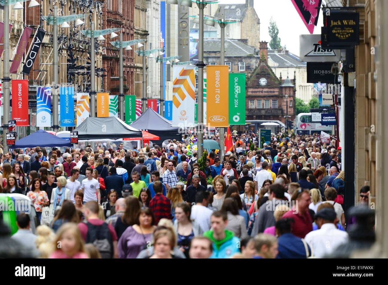 Eine geschäftige Buchanan Street im Stadtzentrum von Glasgow mit bunten Bannern, die Besucher vor den Glasgow 2014 Commonwealth Games, Schottland, Großbritannien, begrüßen Stockfoto