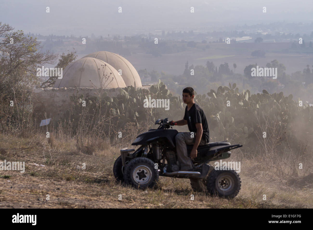 Unteren Galiläa, Israel. Ein Teenager treibt ein ATV in der Nähe von einem alten Schrein im Beit She'arim National Park. Stockfoto