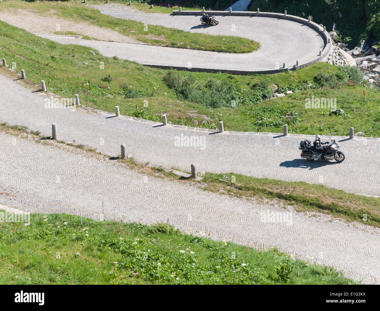 Motorrad-Touristen treiben die Kopfsteinpflaster asphaltierten Straße ("Tremola") auf der historischen Mountain Pass San Gottardo, Schweiz. Stockfoto