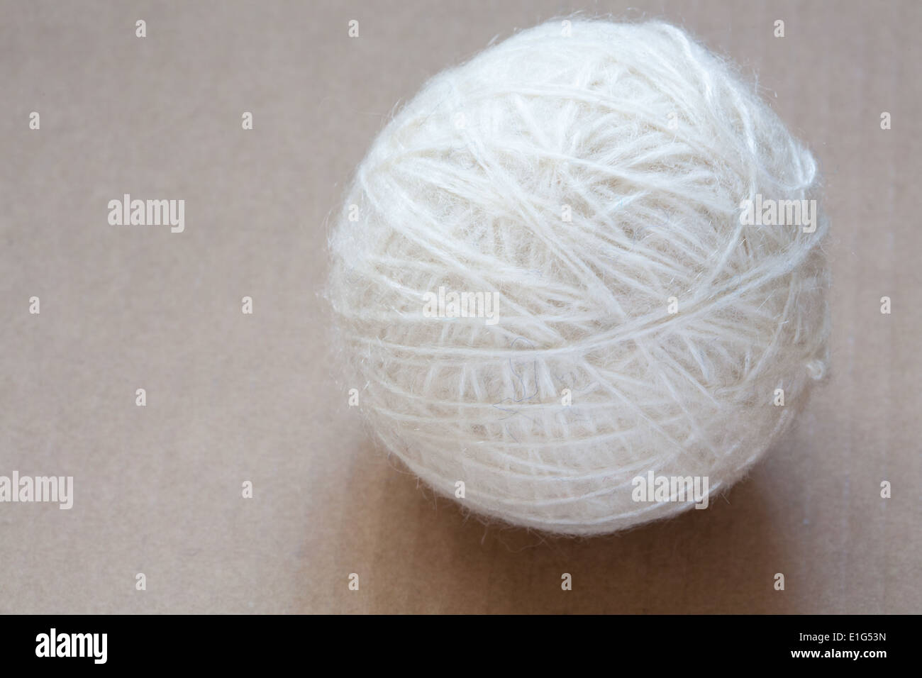 Weiße Wolle Wollknäuel auf Karton Hintergrund Stockfoto