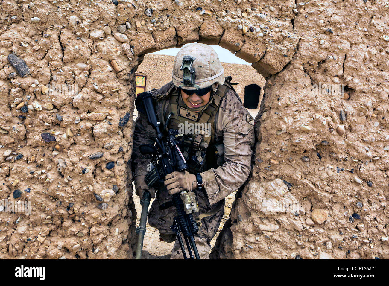 US Marine LCpl. Joseph Guthrie III drückt durch eine Öffnung in eine verlassene Verbindung während einer Patrouille Reconnaissance 15. Mai 2014 in der Nähe von Patrol Base Boldak in der Provinz Helmand, Afghanistan Schlamm. Stockfoto
